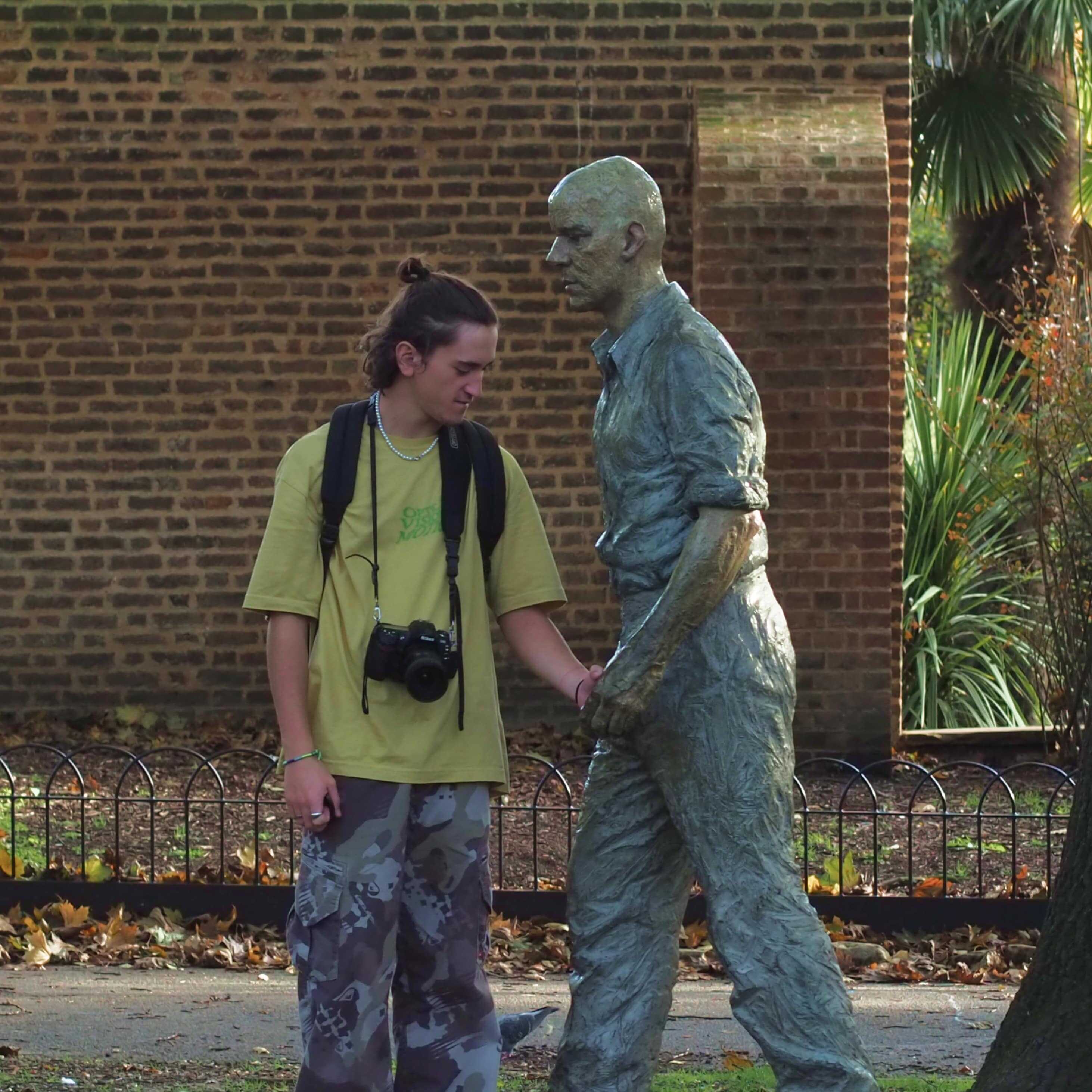 Photo de Thomas Devred qui tient la main d'une statue