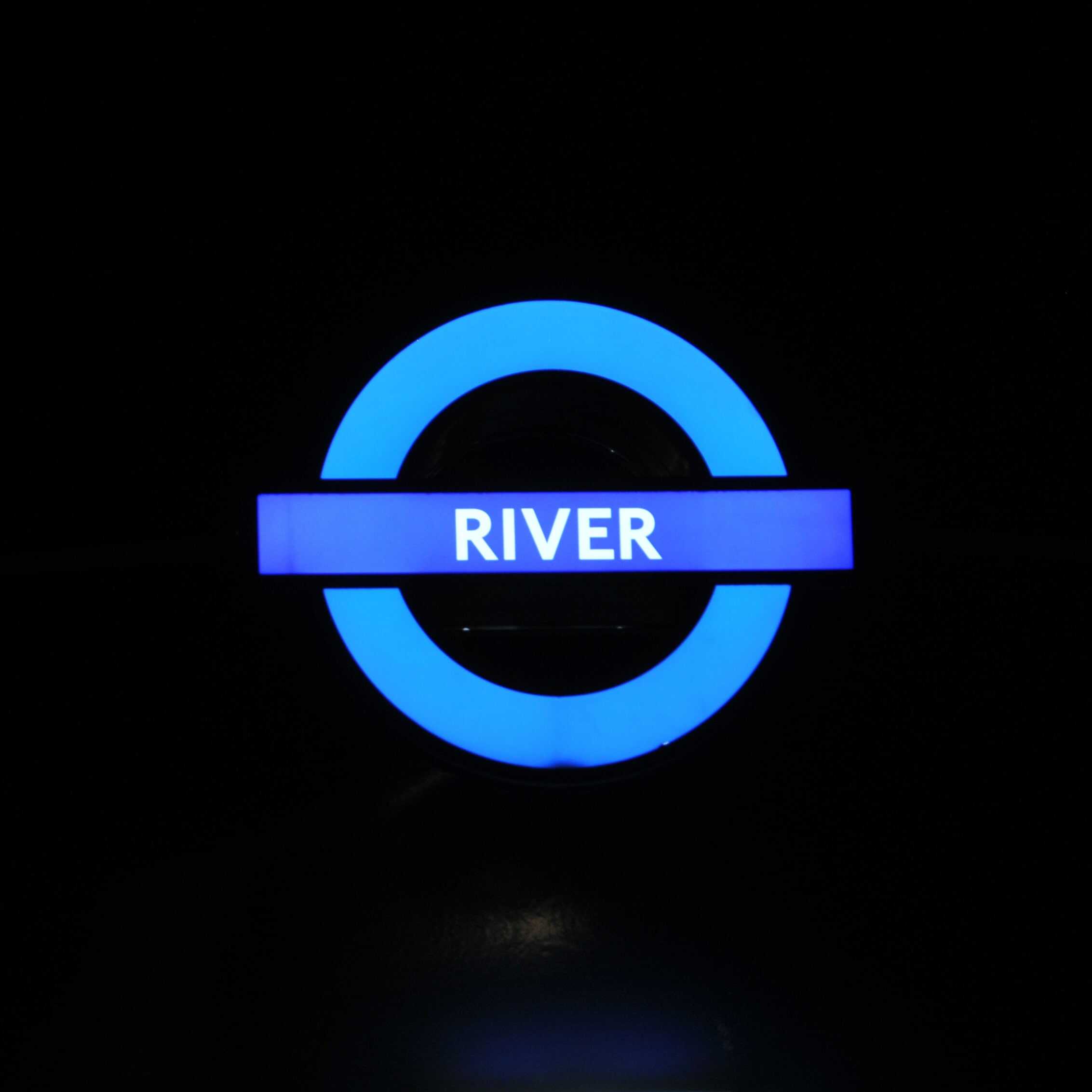 Photo d'un panneau londonien bleu lumineux